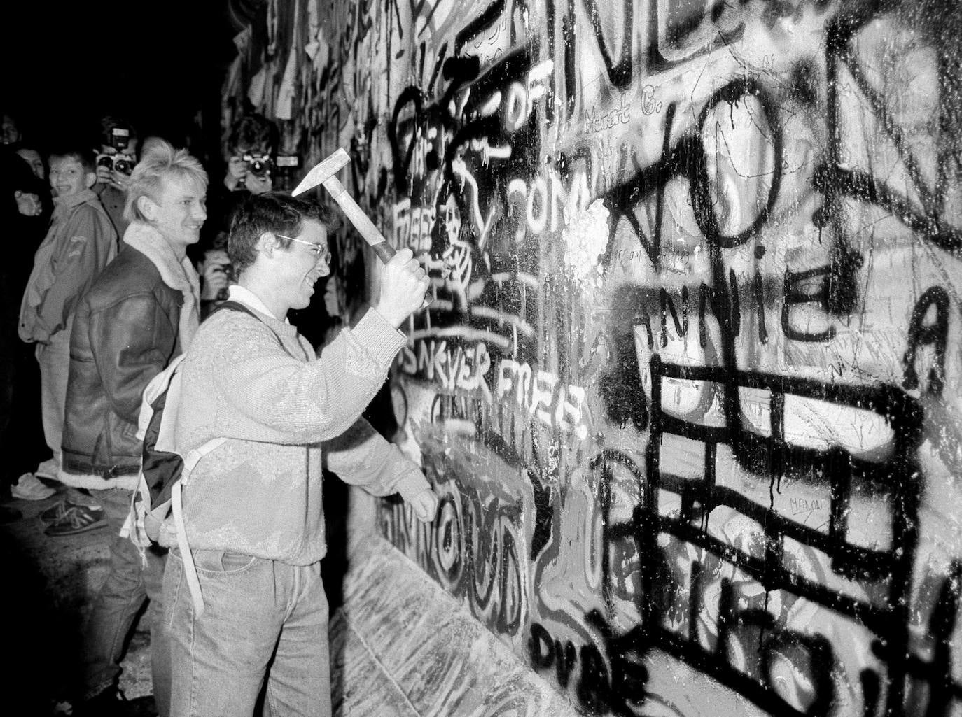 (3) Antes: Un hombre golpea con un martillo el Muro de Berlín cerca de la plaza Potsdamer Platz después de que se anunciara la apertura de la frontera de Alemania Oriental, el 9 de noviembre de 1989.