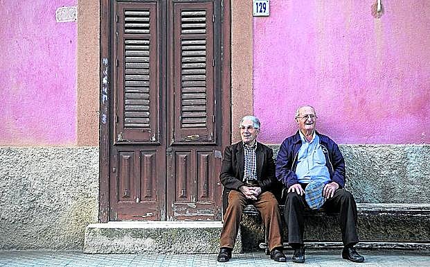 Imagen principal - Arriba, dos ancianos sentados junto a una casa en Campofelice di Fitalia. Una de las viviendas que se venden por un euro en Sambuca di Sicilia, declarado uno de los pueblos más bonitos de Italia en 2016 y una calle de Roccamena, amenazado por la despoblación.