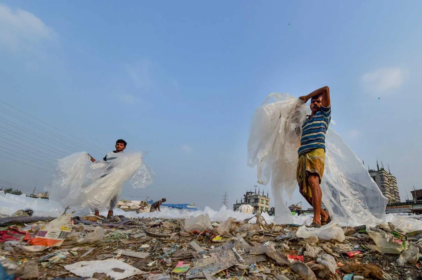 Trabajadores prepara las bolsas de plástico utilizadas para transportar productos químicos para que se sequen junto al río Buriganga en Dhaka, Bangladesh