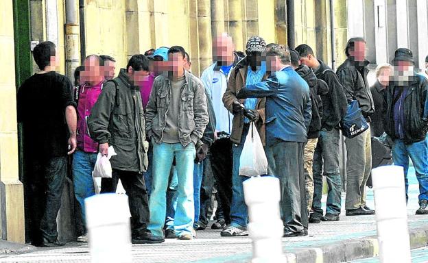 Varias personas aguardan para entrar a un comedor de Cáritas en San Sebastián.