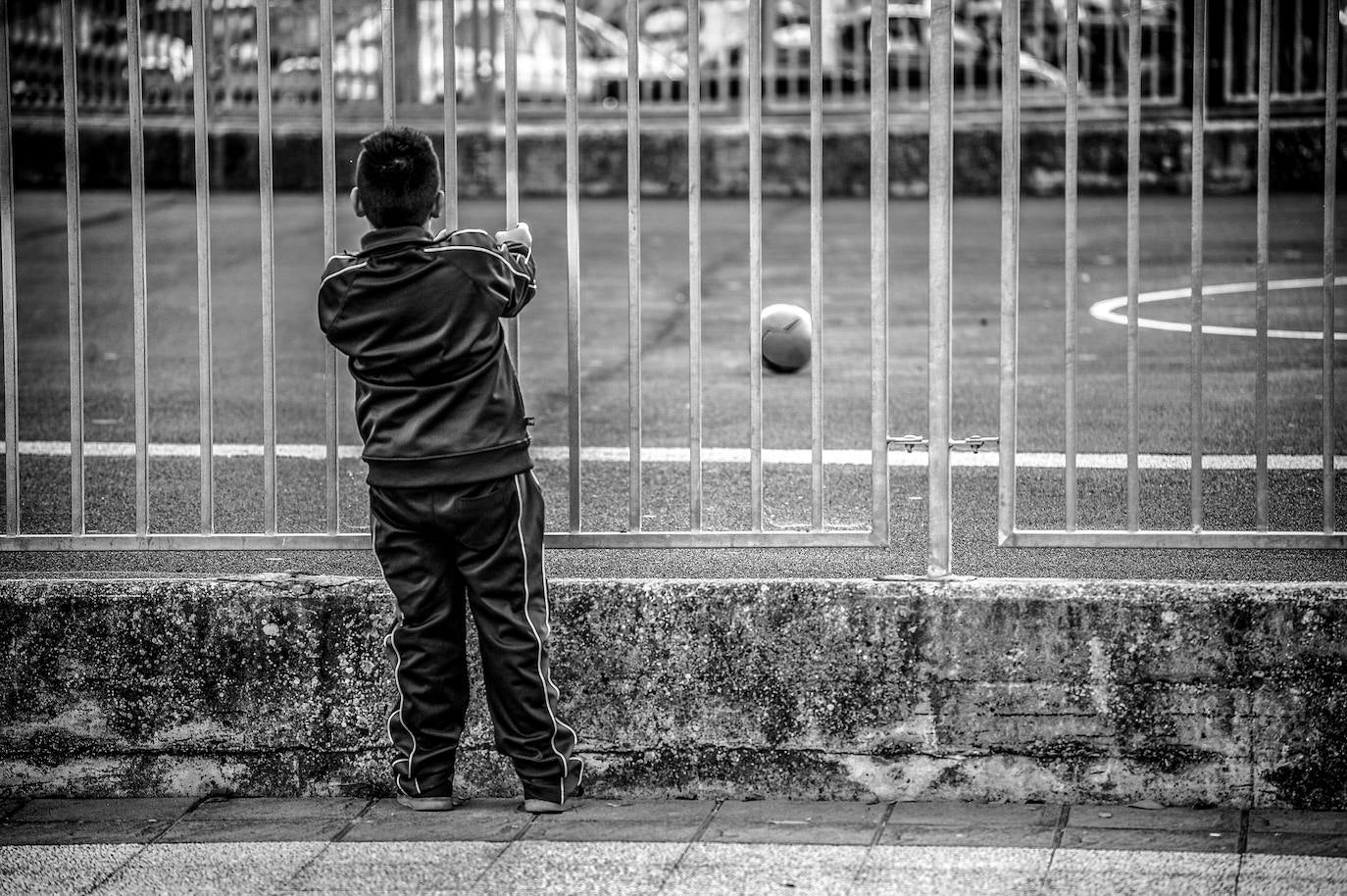 Un niño observa el balón que se ha colado en el interior del colegio IPI Sansomendi. 