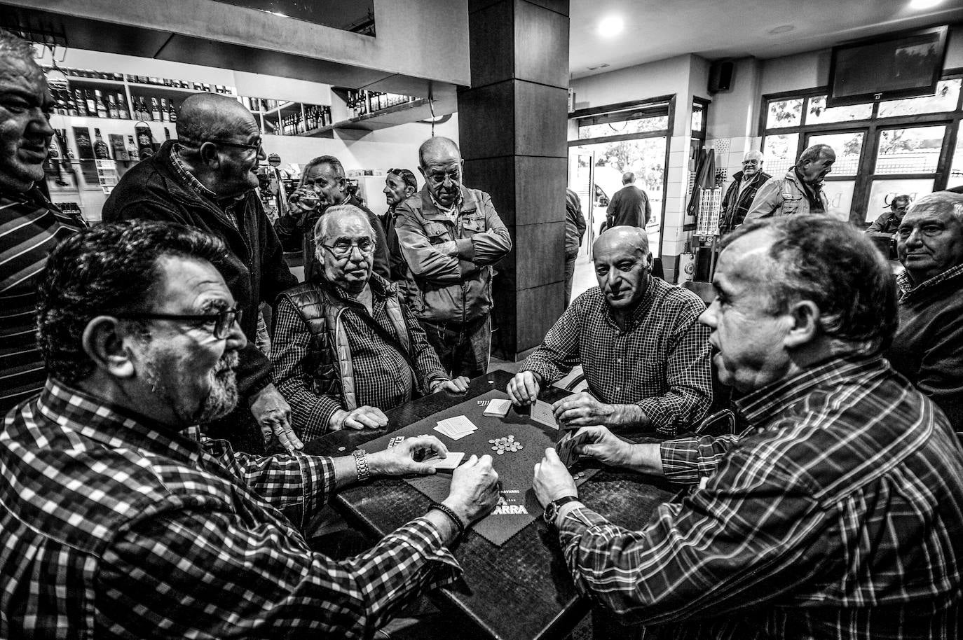 Una buena partida de mus por la tarde en el bar El Encuentro atrae el interés de los vecinos.