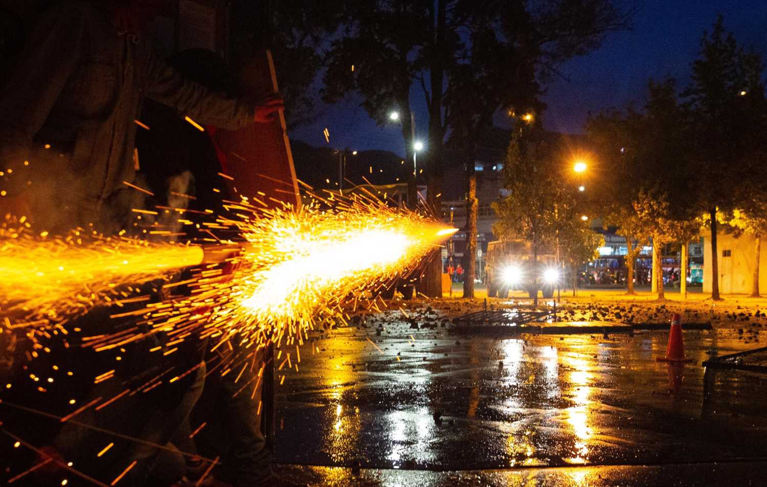 Manifestantes lanzan un artefacto contra una tanqueta de la policía durante el sexto día de protestas y movilizaciones antigubernamentales, en Bogotá (Colombia). 