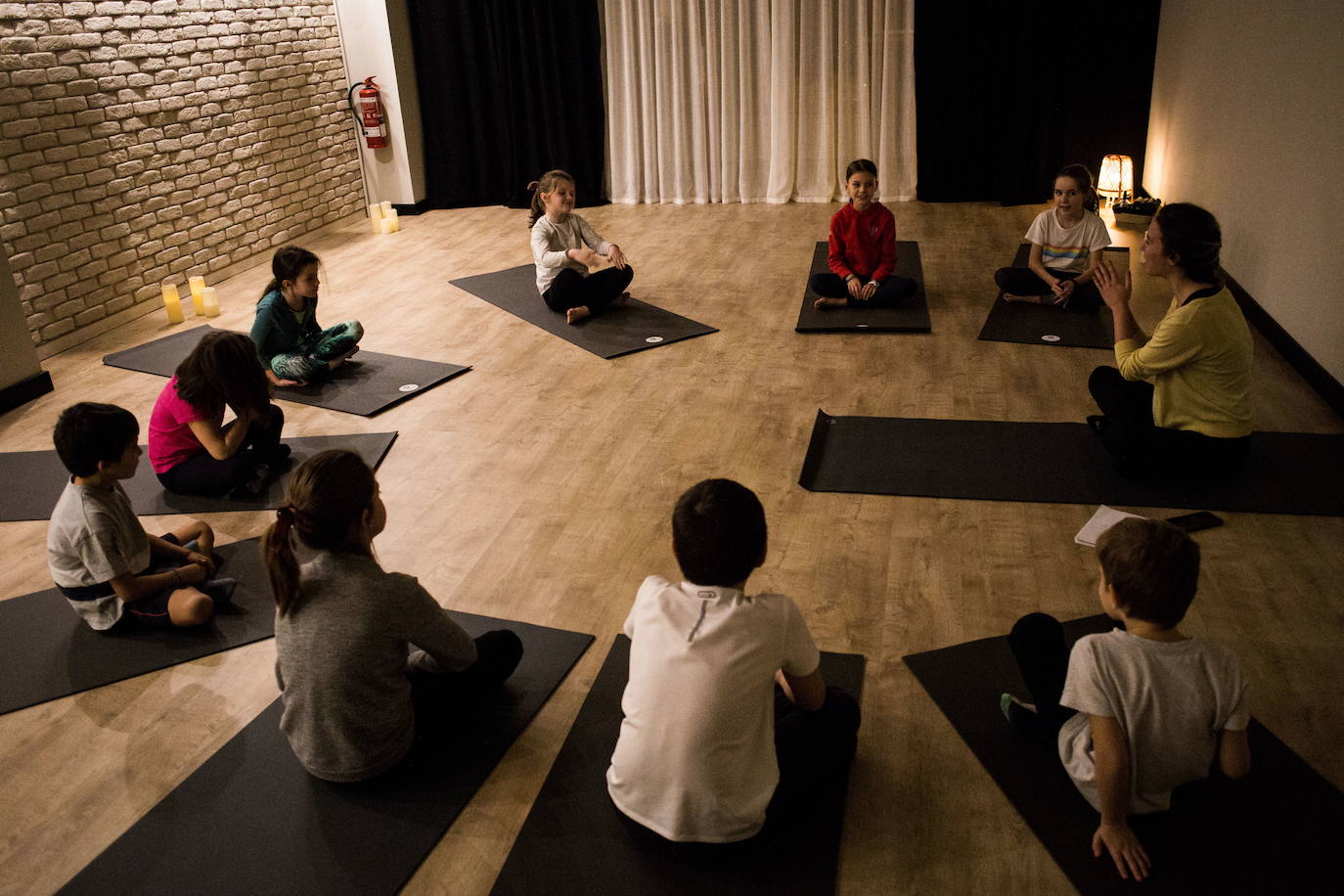 Los niños atienden en círculo a su profesora.