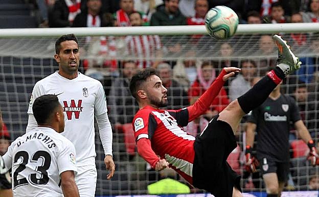 El centrocampista controla un balón ante la atenta mirada de dos jugadores del Granada. 