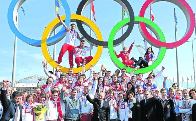 Vladimir Putin posa junto al equipo olímpico ruso durante los Juegos de Invierno que se celebraron en Sochi en 2014. 