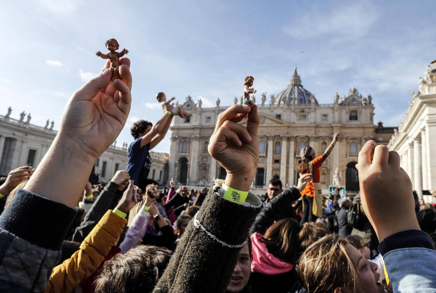 Jóvenes muestran figuras del Niño Jesús durante el rezo del Ángelus dominical del papa Francisco en la Plaza de San Pedro del Vaticano.