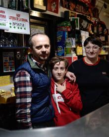 Imagen secundaria 2 - Óscar Telletxea y su perro se encomiendan a la suerte. En medio, David Lobato, uno de los tres socios de la administración. Abajo, Toni, Mariana y su hijo Pavel, que regentan el Bar Oregi que repartió varios décimos de la Lotería Nacional premiada hace un mes.