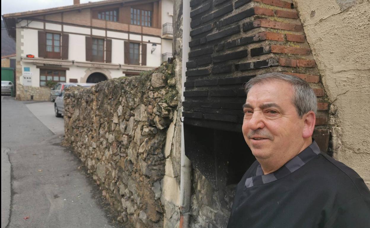 Javi San Vicente, patrón del Obenkun (al fondo) junto al horno hecho con sus manos hace 30 años donde asa sus corderos.