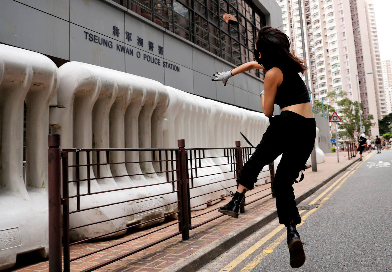 Hong Kong | Un manifestante contra el proyecto de ley de extradición arroja una piedra a una estación de policía en el distrito residencial de Tseung Kwan O, 4 de agosto de 2019. 