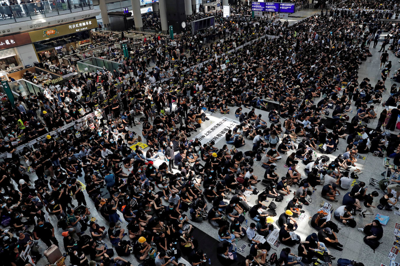 hong Kong | Los manifestantes contra el proyecto de ley de extradición asisten a una manifestación masiva después de que una mujerr ecibiera un disparo en el ojo durante una protesta en el Aeropuerto Internacional de Hong Kong,12 de agosto de 2019. 