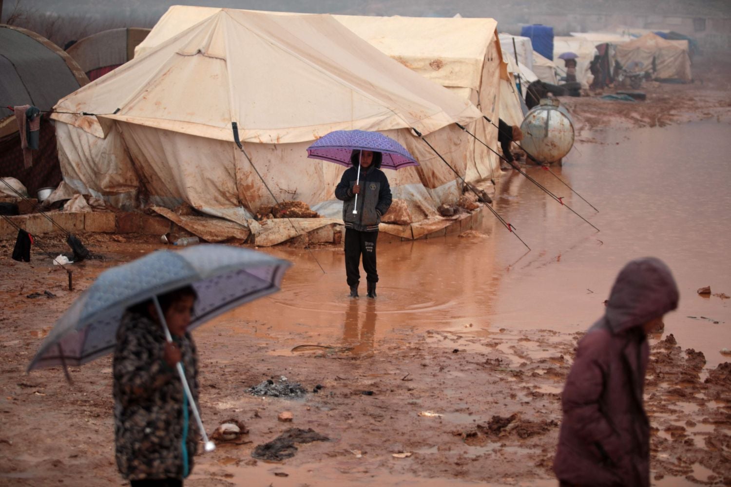 Niños sirios huidos de la batalla de Idlib, entre el barro y la lluvia de un campo de refugiados en Kafr Dariyan, junto a la frontera entre Siria y Turquía