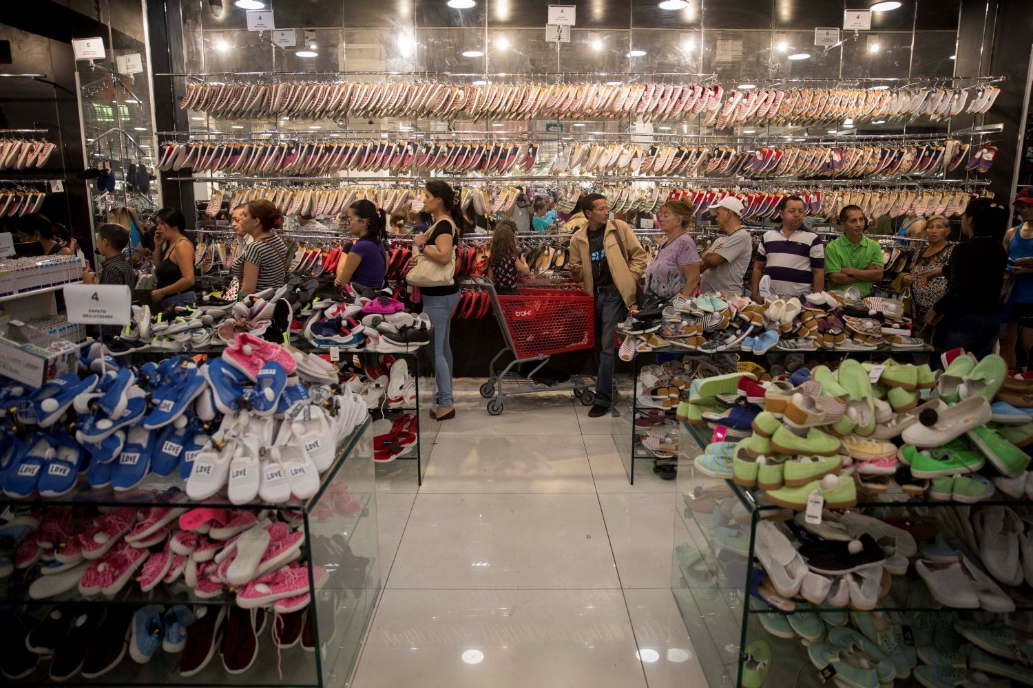 Una larga cola de personas espera para pagar en una tienda que acepta pagos en petros en Caracas (Venezuela). Maduro ha concedido medio petro como aguinaldo a jubilados y funcionarios