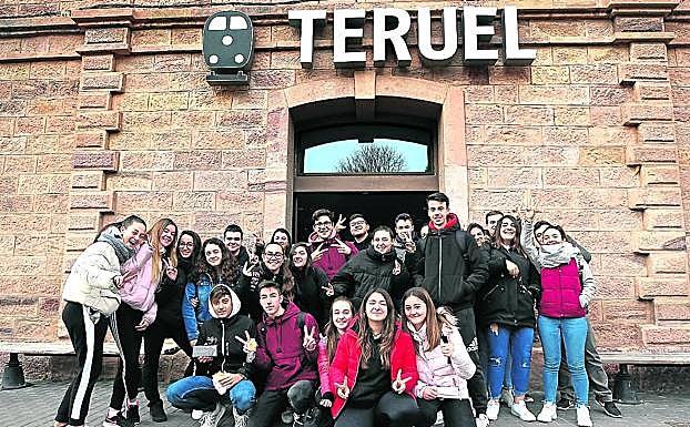 Imagen principal - 1. Estudiantes del instituto Vega del Turia hacen la 'v' de victoria en la estación de Renfe. | 2. Un par de transeúntes pasean bajo el viaducto de Fernando Hué, que une el casco histórico con el Ensanche. | 3. Juan Carlos, un ingeniero agrónomo, y Lourdes, médica, ambos de Almería, consultan el mapa turístico de Teruel desde la torres mudéjar de El Salvador. 