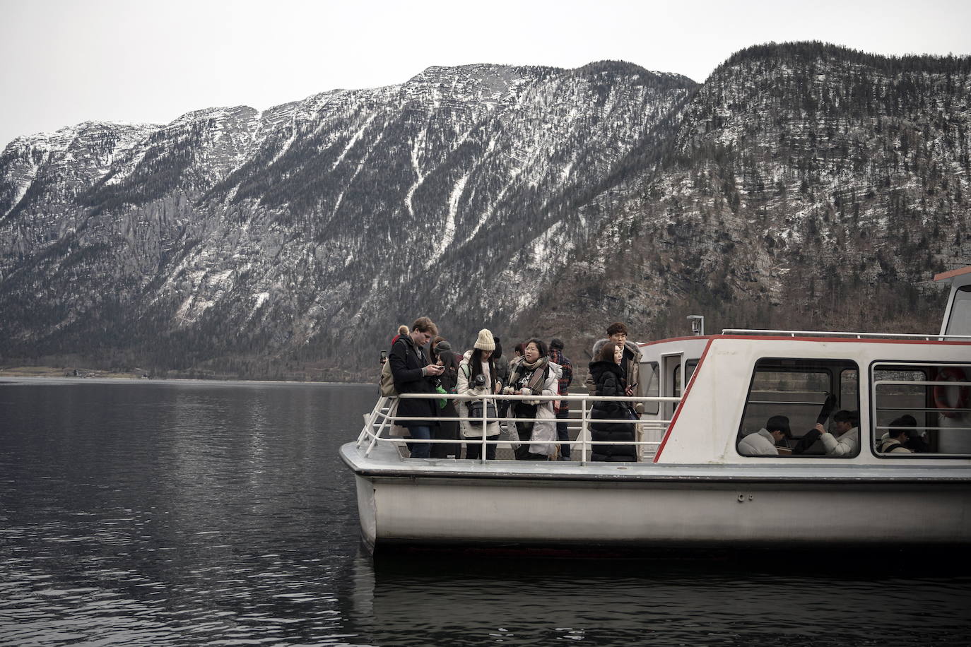 Hallstatt era hace diez años una villa idílica al borde de un lago de ensueño y aún lo sigue siendo, pero de otra manera. Lo que entonces le faltaba al pequeño pueblo austriaco, ahora le sobra. Tiene gente para dar y regalar, la hay por todas partes, tanta que hasta los visitantes se cuelan sin permiso en las casas en busca de un baño que no esté ocupado. En el pueblo residen 778 vecinos pero no lo parece porque apenas se les ve. Su presencia se diluye ante las riadas de personas que transitan por las calles en busca de un lugar vacío donde sacarse una foto mientras decenas de drones sobrevuelan los tejados para obtener imágenes impactantes. Hay turistas que llegan a la localidad convencidos de que se encuentran en un parque temático donde todo es de cartón piedra y todo está a la venta. Otros creen que están recorriendo el auténtico Arendelle, el reino de la película 'Frozen'. Hallstatt es un pueblo de moda, hasta ha sido calificado como «el más 'instagrameable' del mundo», y eso está siendo su ruina