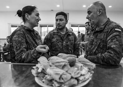 Imagen secundaria 1 - Adiestramiento. Un pelotón ensaya técnicas de combate urbano en módulos de hormigón que recrean calles y casas. A continuación, la cantina, donde la cabo Arranz y el brigada Varela charlan durante un descanso. Este servicio y el rancho están subcontratados. Finalmente, un soldado se desliza haciendo rápel por la rampa de la torre multiusos mientras le sujeta su instructor.