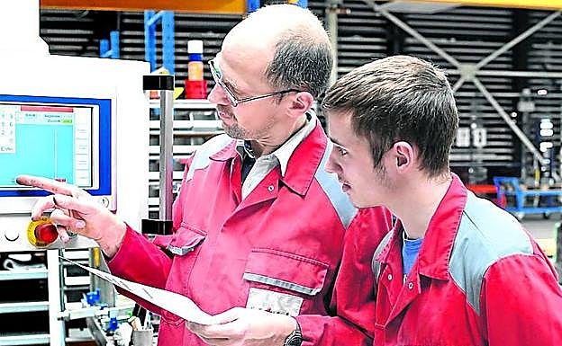 Un técnico especialista instruye a un alumno en prácticas. 