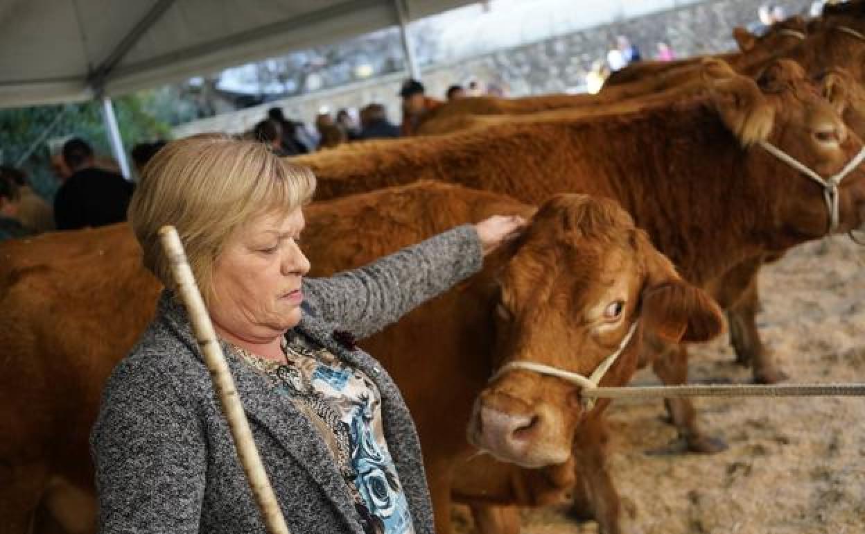 Elena Gastelurrutia posa en el recinto ferial junto a algunas cabezas de su ganadería de vacuno que regenta en la localidad de Abadiño. 