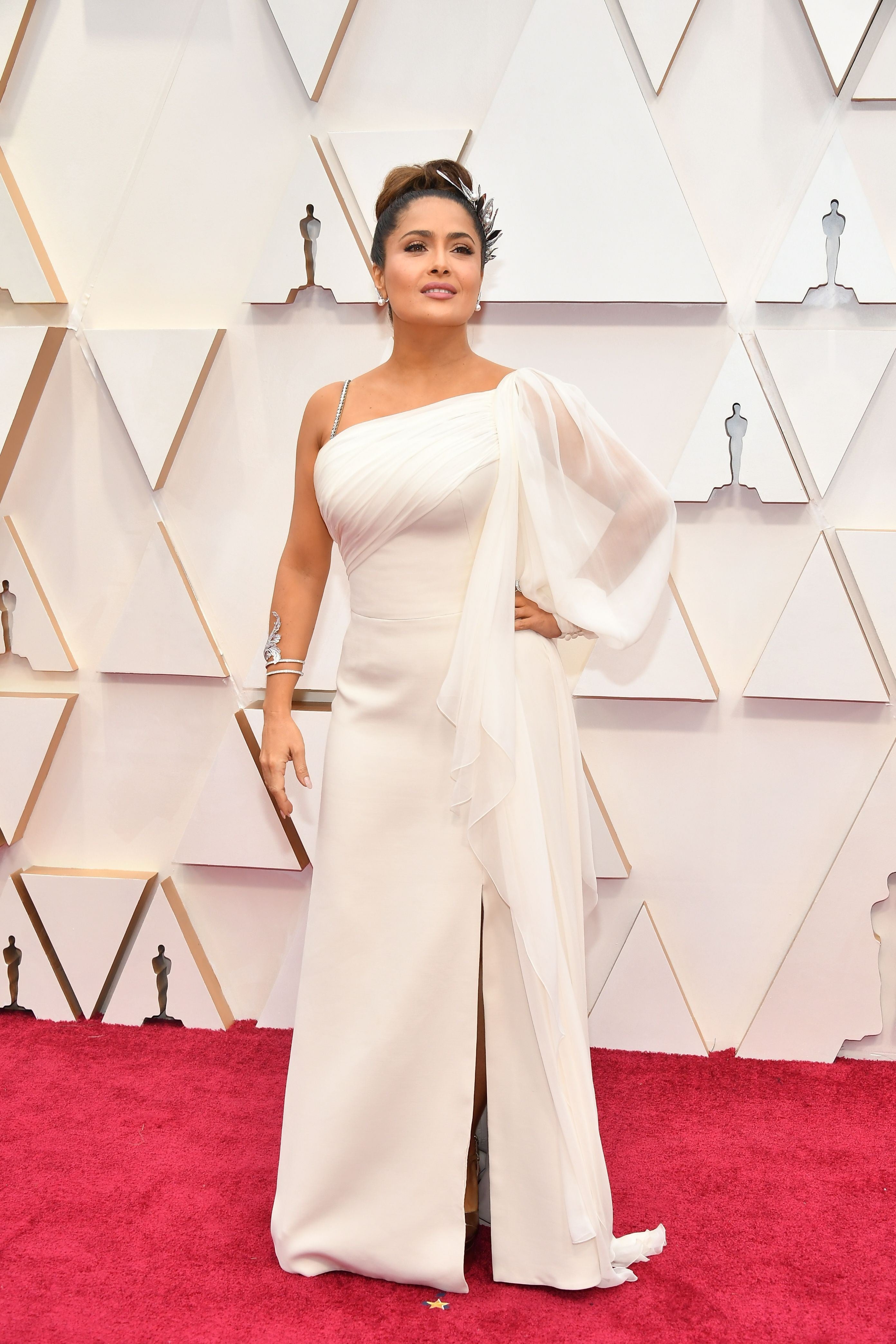 Salma Hayeck tampoco ha estado demasiado acertada con un look de inspiración griega demasiado obvio. Aplicar la tendencia helénica está bien en pequeñas dosis, pero la actriz se ha puesto hasta la tiara floral a juego de un vestido blanco, vaporoso y con escote asimétrico, firmado por Gucci.