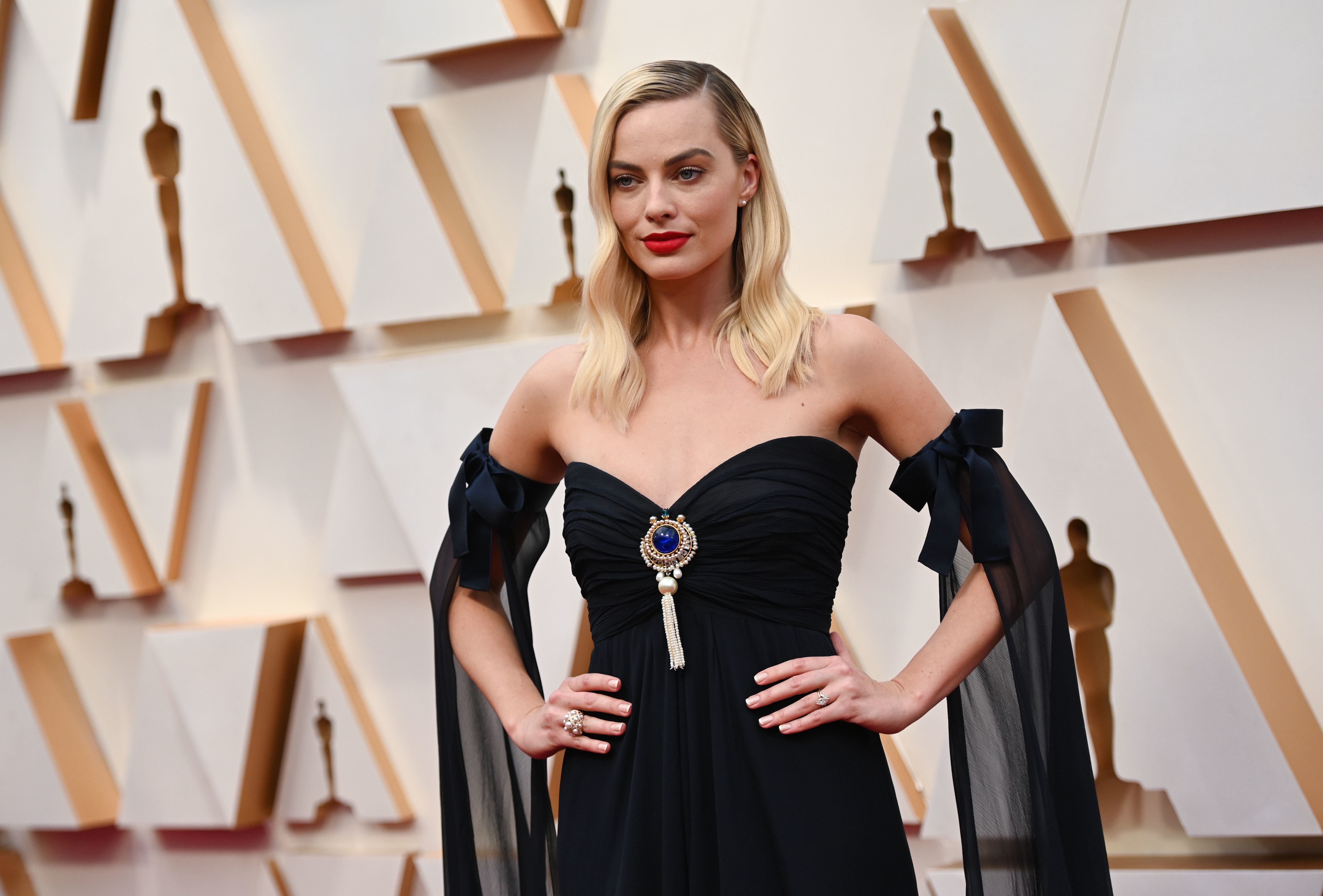 En la categoría a ‘Mejor Actriz secundaria’ también va a pelear Margot Robbie, que interpreta a una periodista recién llegada a Fox News en ‘El escándalo’. La nueva musa de Chanel vuelve a apostar por su firma de referencia y por el color negro, que vuelve con fuerza en esta alfombra roja. Lo curioso es que se trata de una creación ‘vintage’ de 1994 de Chanel Alta Costura, con lo cual se suma a la oleada sostenible que ha promovido la propia organización de los Oscar. Se trata de un diseño de escote corazón drapeado, con falda asimétrica y caída, que completa con un magnífico broche azul y dorado y unas mangas de gasa semitransparentes con lazada.