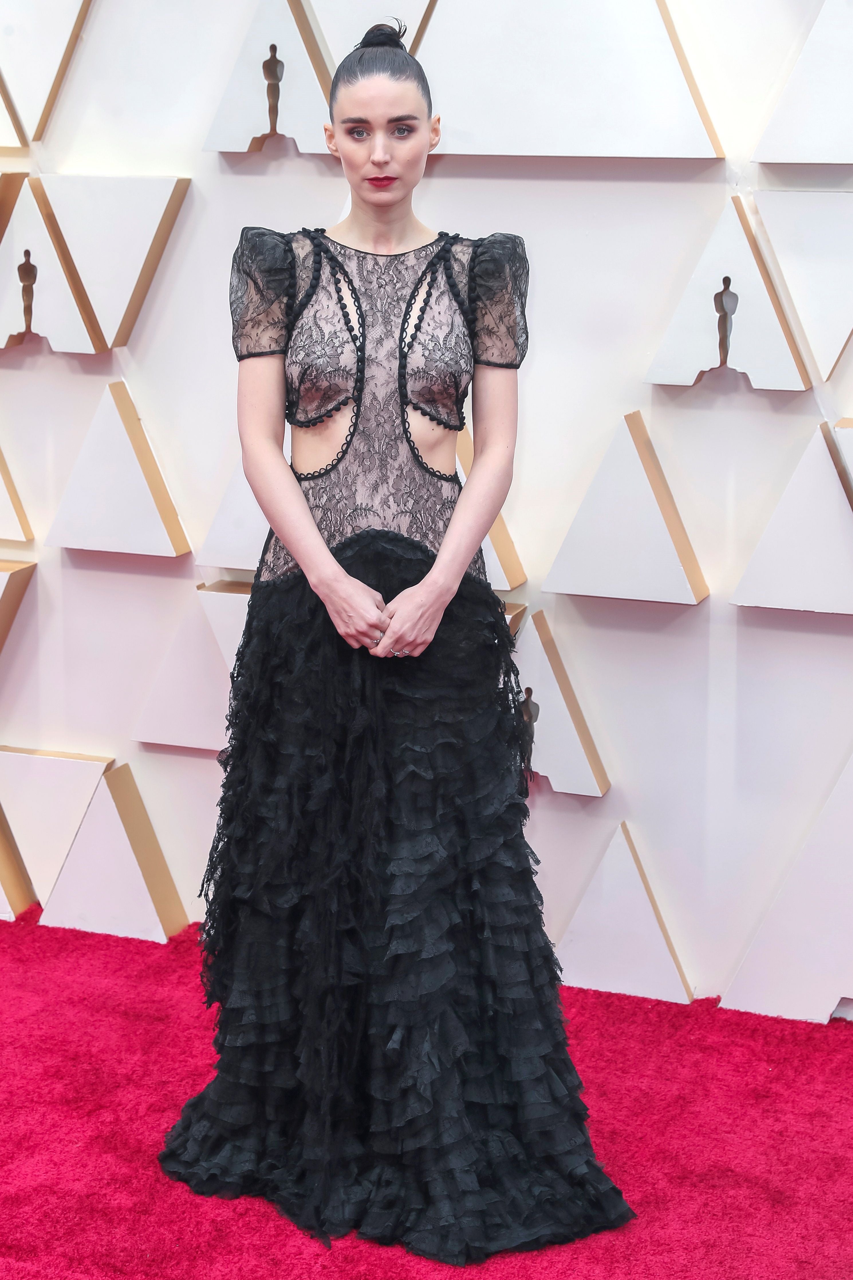 Rooney Mara, como es habitual, vuelve a apostar por el negro y consigue hacerlo especial a base de bordados que parecen una segunda piel. Y es que ha elegido un diseño de Alexander McQueen con un cuerpo semitransparente de mangas abullonadas y ‘cut-outs’ estratégicos que compensa con una falda de microvolantes.