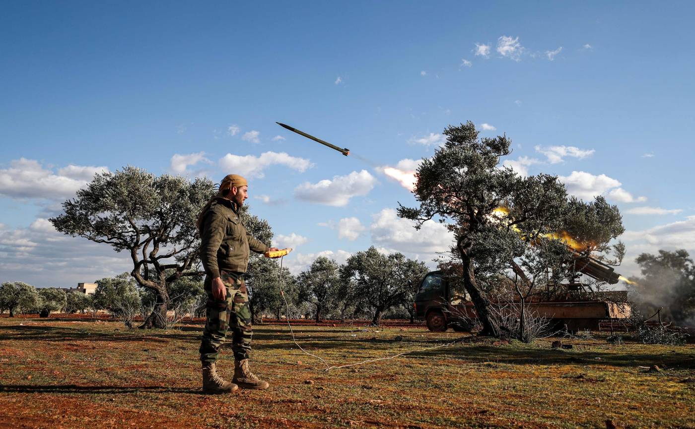 Un combatiente rebelde sirio dispara remotamente un cohete desde un lanzador montado en un camión en una posición del campo de Idlib, hacia posiciones de las fuerzas del régimen en el campo sur de la provincia de Alepo, Siria.