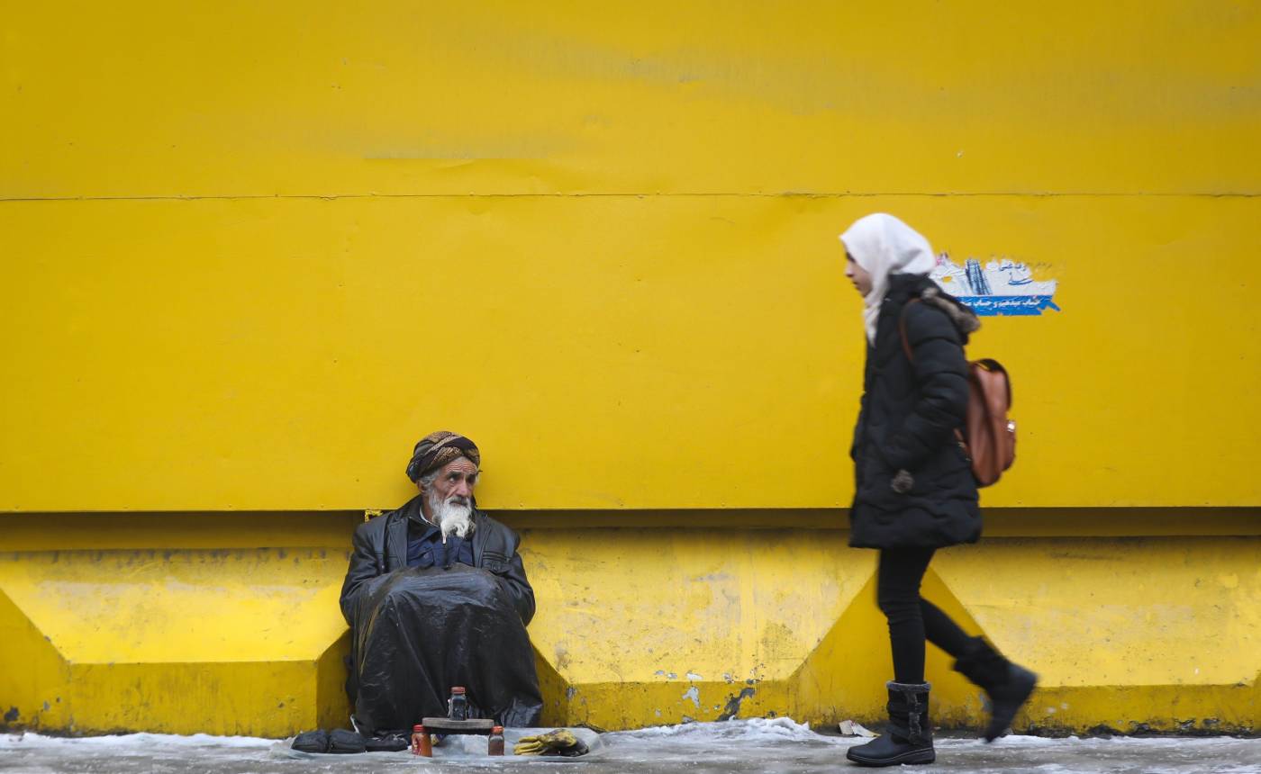 Un limpiabotas afgano espera clientes en una calle de Kabul (Afganistán). 