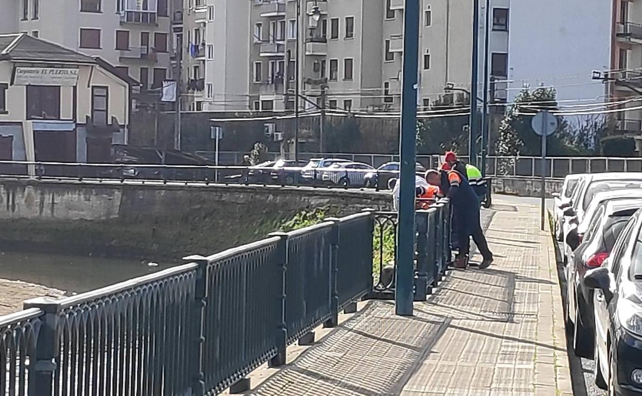 Los trabajadores pintan la barandilla del corte de la ría. 