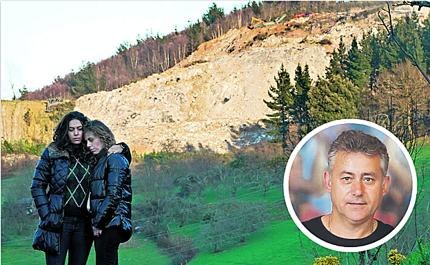 Gema y Bego, hermanas de Joaquín, se abrazan en el barrio de Eitzaga, en Zaldibar. Al fondo, se observa parte de la avalancha ocasionada por el colapso del vertedero. 