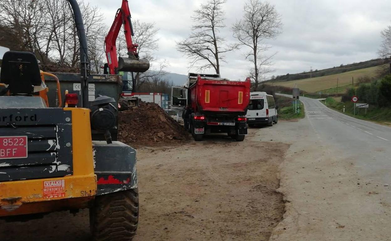 El micobús escolar se encuentra estacionado delante del camión rojo.