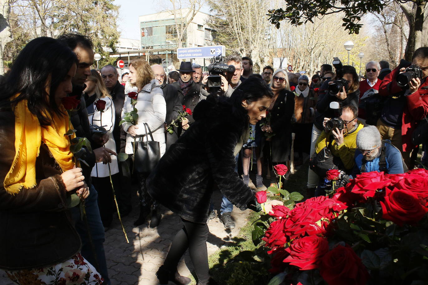 Marta Buesa coloca una rosa roja ante el monolito en homenaje a su padre.