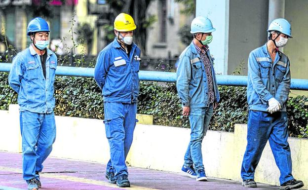 Trabajadores en una calle de Guangzhou, en la provincia de Guangdong. El coronavirus mantiene al país en cuarentena.