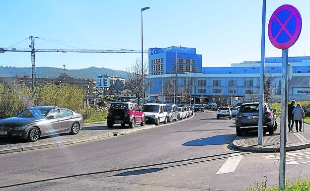 Coches estacionados sobre las aceras en el entorno del hospital, al fondo de la imagen. JON ANDER GOITIA