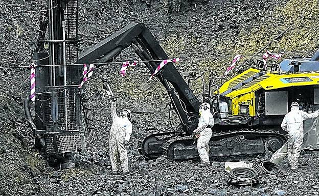 Operarios trabajan en la instalación de unas mallas de seguridad para proteger la autopista en el entorno del vertedero de Zaldibar.