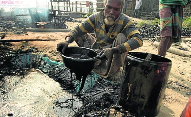 Sin medios. Así hacían los habitantes de Sundarbans labores de limpieza tras un vertido de crudo.