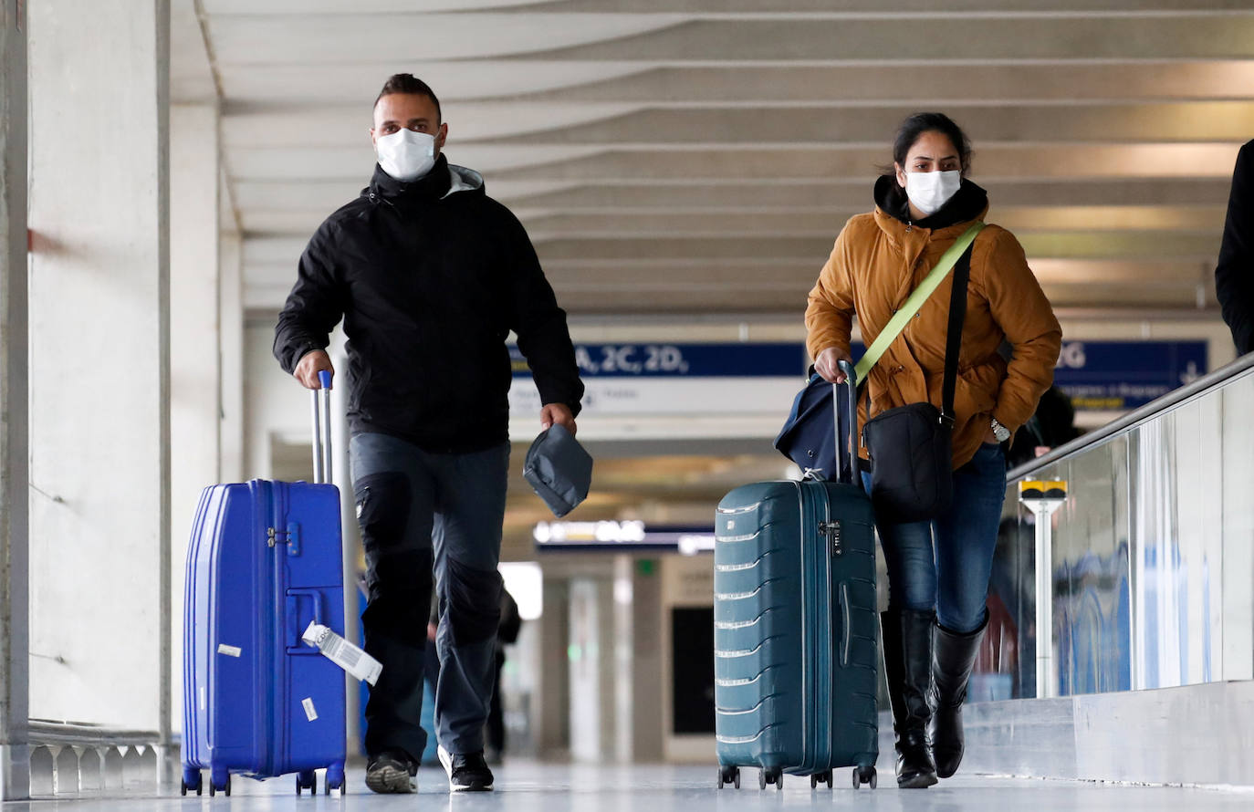 Viajeros con máscaras protectoras, a su llegada al aeropuerto Charles de Gaulle.