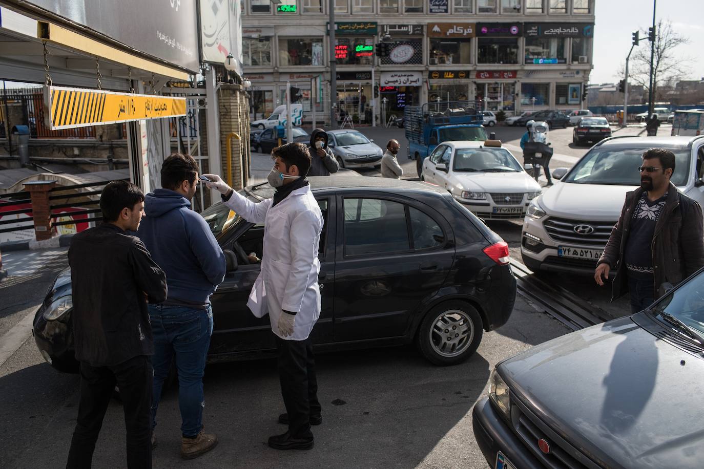 Un inspector sanitario mide la temperatura a un viandante en la entrada de un centro comercial en Teherán.