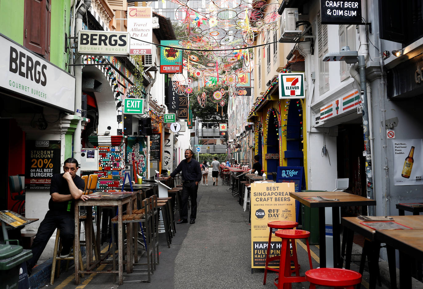 El personal de un restaurante espera a clientes en la céntrica calle de Haji Lane, ahora desierta.