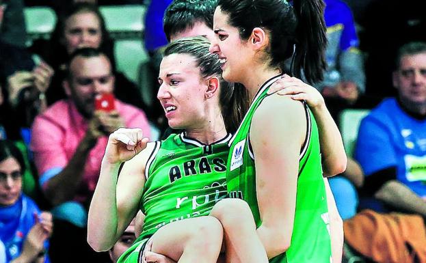 Laura Pardo traslada en volandas a Izaskun García, lesionada en el tobillo en el choque ante el Lointek. 