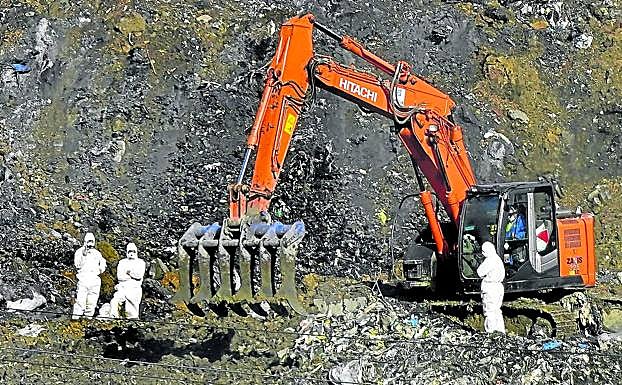 Varios operarios trabajan en el cribado de los residuos en la zona B-4 del vertedero derrumbado.