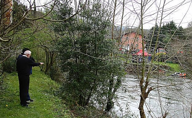 Dos hombres observan las inmediaciones del lugar del accidente.