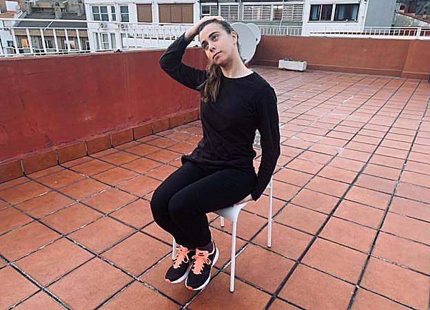 Una modelo realiza el estiramiento para el trapecio superior.