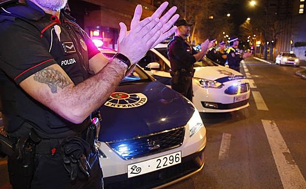 Ertzainas y policías locales aplauden al personal y pacientes del hospital Santiago. 