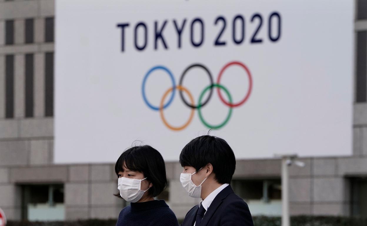 Imagen de Tokio, con dos ciudadanos con mascarilla. 