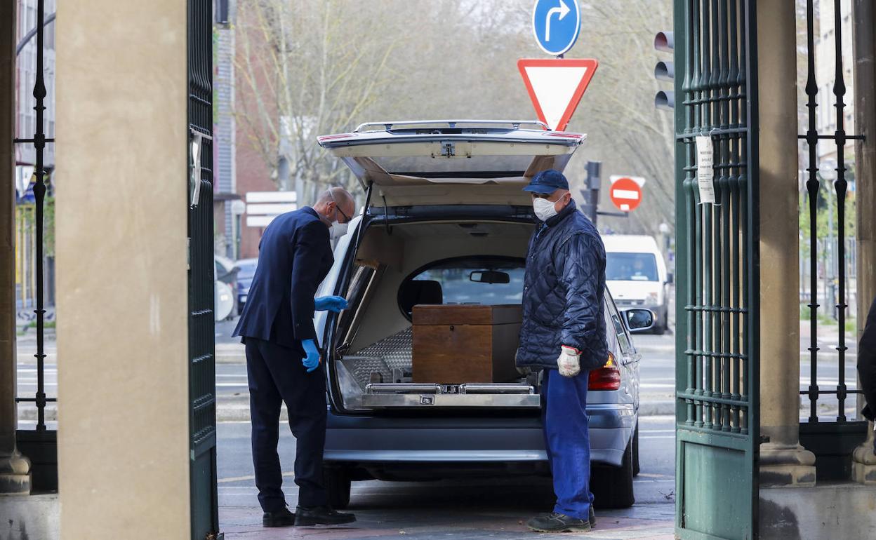 Dos empleados con un ataúd en el cementerio vitoriano de Santa Isabel. 