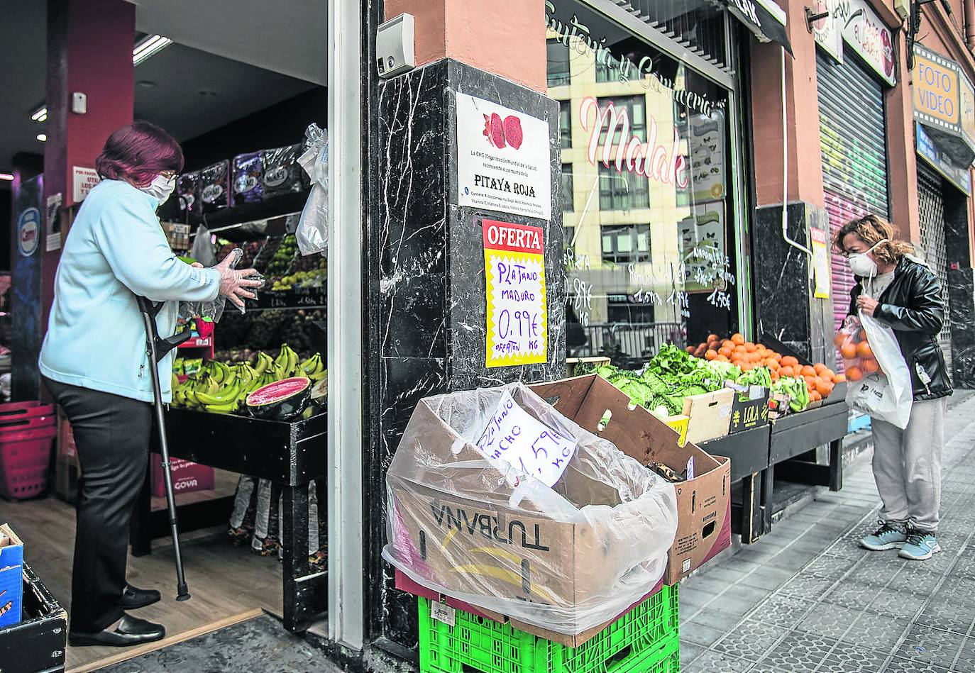 Una mujer hace la compra con medidas de protección. 