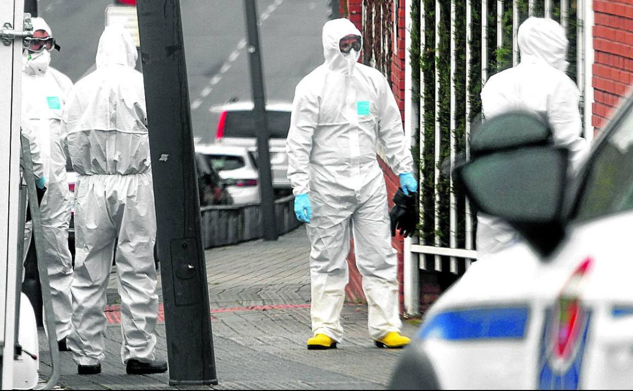 Agentes de la Ertzaintza, con buzos especiales, a la entrada de la comisaría de Txurdinaga. 