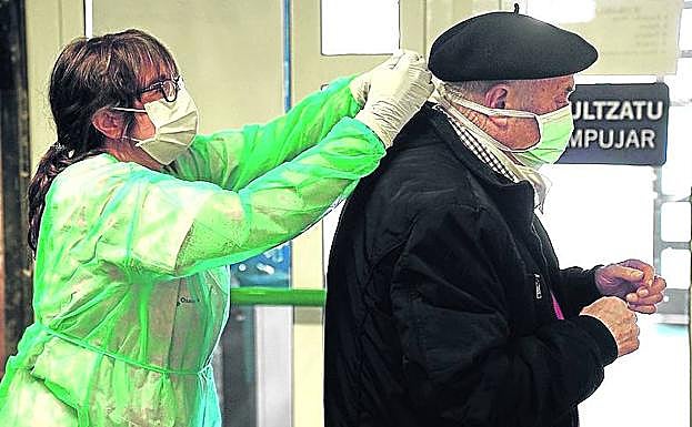 Una enfermera coloca la mascarilla a un mayor en Deusto. 