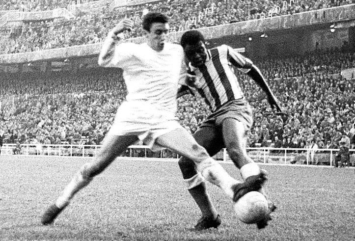 Jones lucha por un balón con Pachín, jugador del Real Madrid.