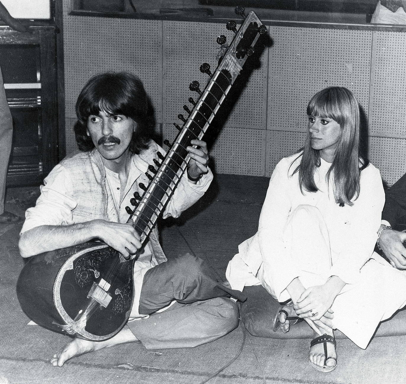 1968. George Harrison, miembro de The Beatles, toca la sitar, instrumento de cuerda típico de la India. A la dcha., la actriz británica Rita Tushingham.